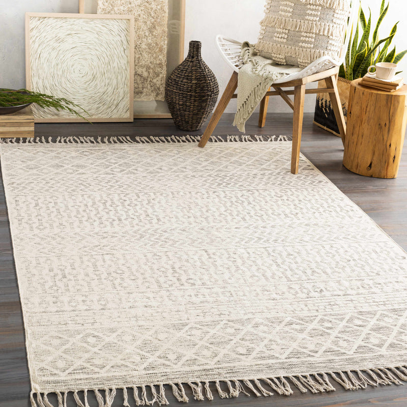 Beige hand-woven cotton rug by Boutique Rugs in a room setting, showcasing its textured, natural appearance and soft, neutral color.