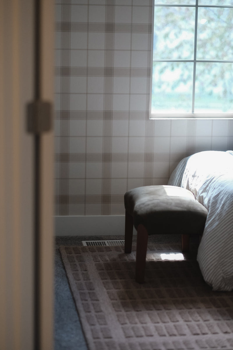 Henry Plaid wallpaper by North and Finch features classic plaid pattern in muted tones, ideal for versatile interior decor.