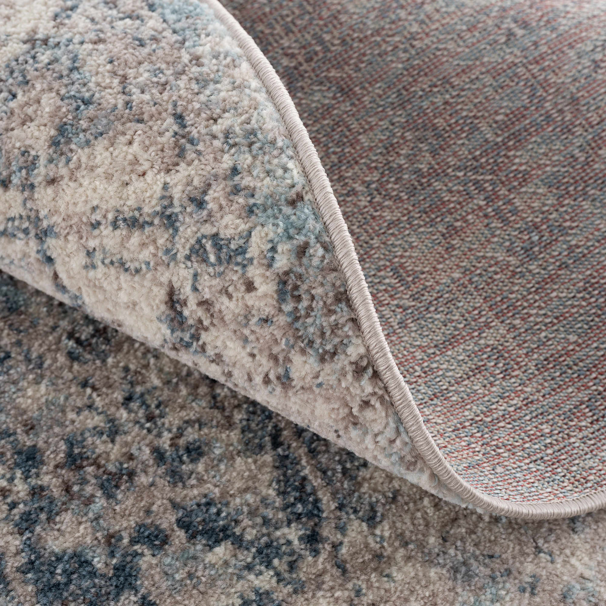 Folded red Orrick area rug from Boutique Rugs showcasing soft textile and stylish design in a cozy setting.