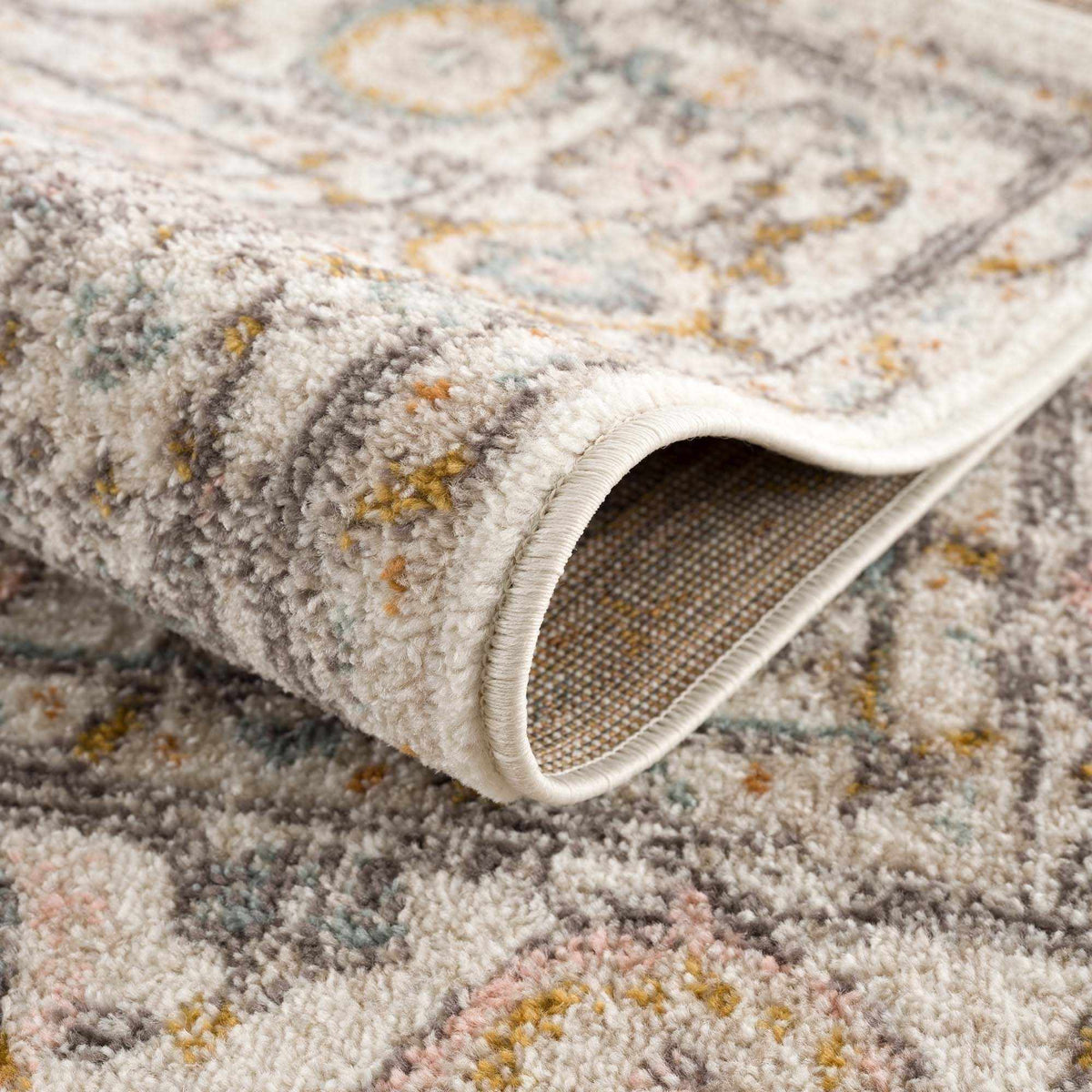 Herstmonceux area rug by Boutique Rugs, folded to show intricate pattern and soft texture in neutral tones.