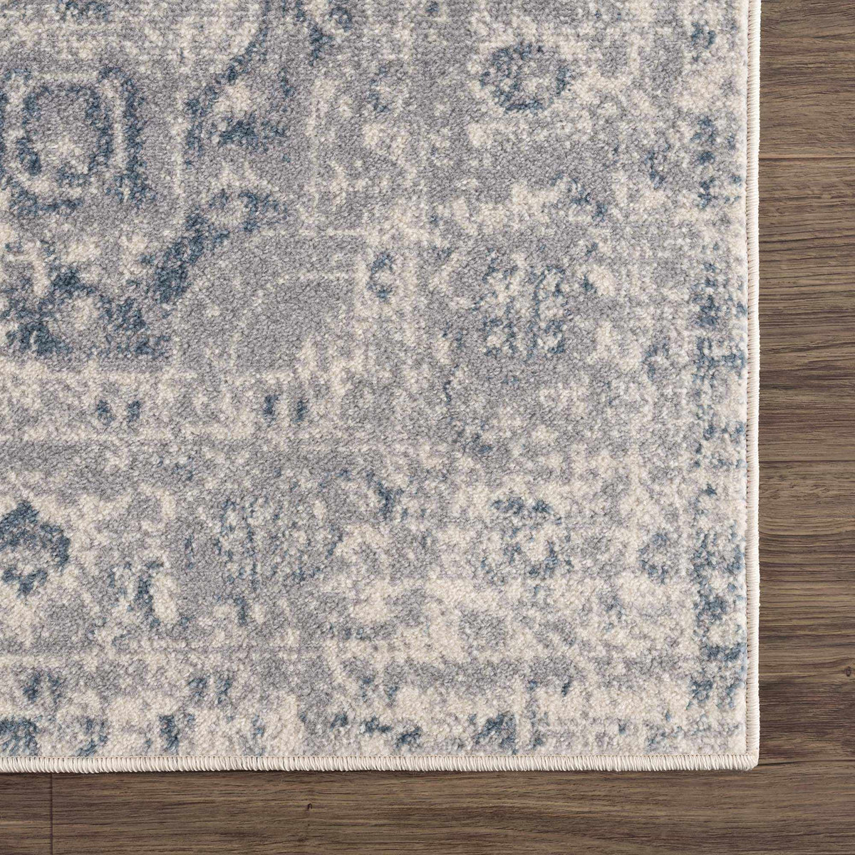 Corner view of Hauteloom Peeta Gray Blue Medallion Area Rug showcasing intricate medallion pattern and soft gray-blue tones.