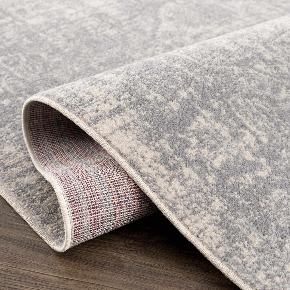 Hauteloom Peeta Gray Medallion Area Rug featuring a detailed medallion pattern in shades of gray, shown folded on a studio background.