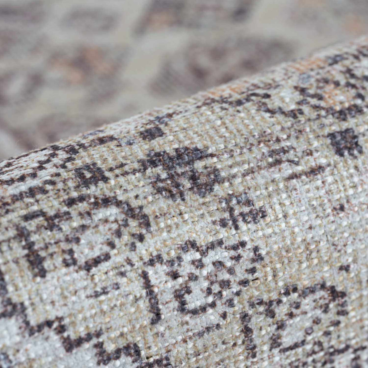Folded Barny Tan washable area rug by Boutique Rugs, showing textured fabric and neutral tan color for living room decor.