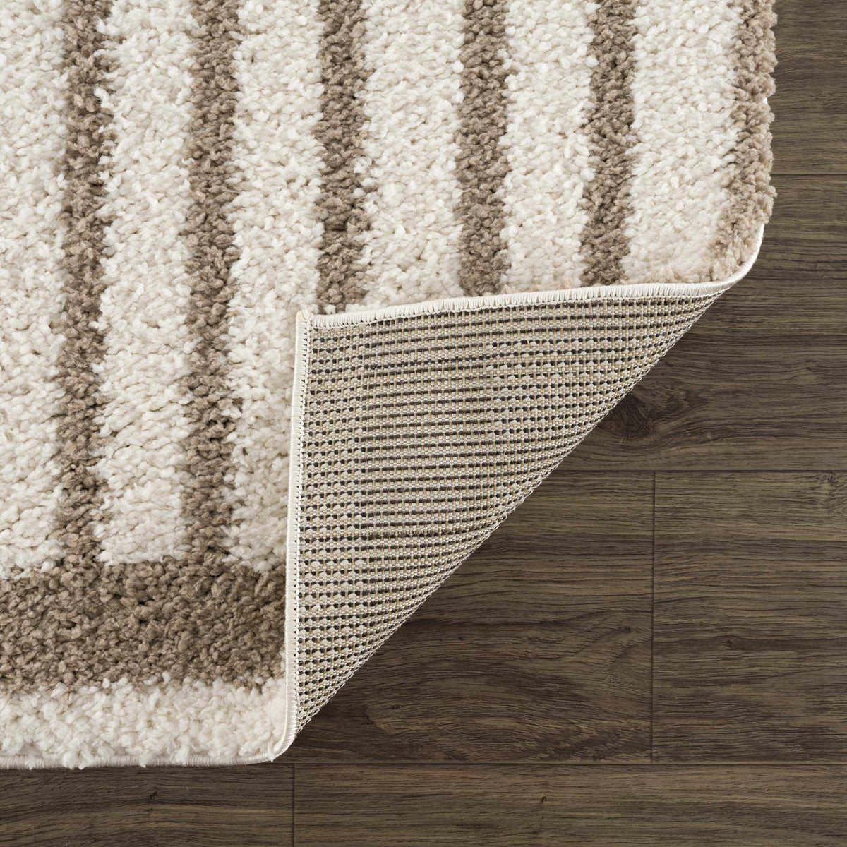 Folded Jola beige area rug from Boutique Rugs, showcasing soft woven texture and neutral color, ideal for living room decor.