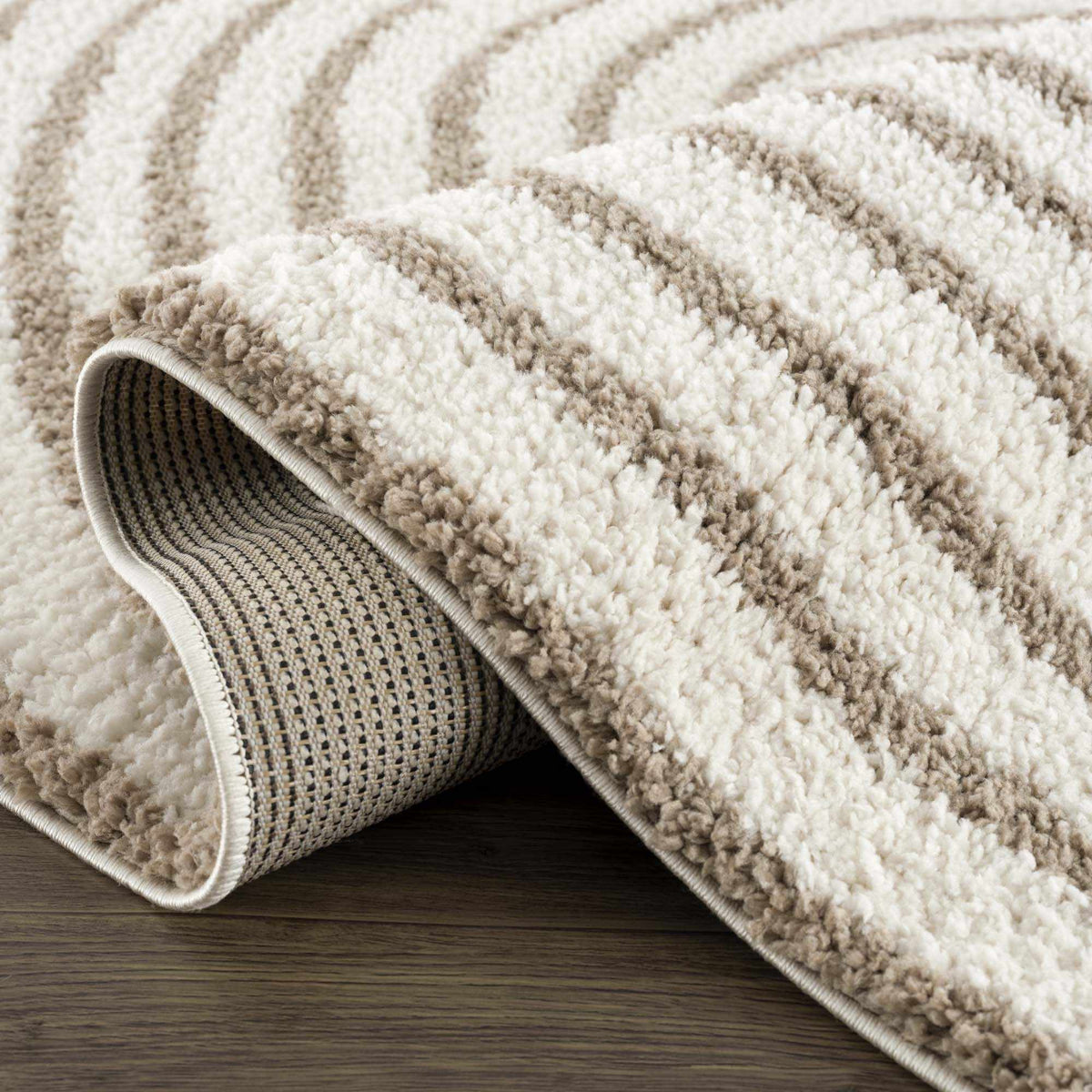 Folded beige Jola area rug from Boutique Rugs, showcasing soft texture and elegant design for living room or bedroom decor.
