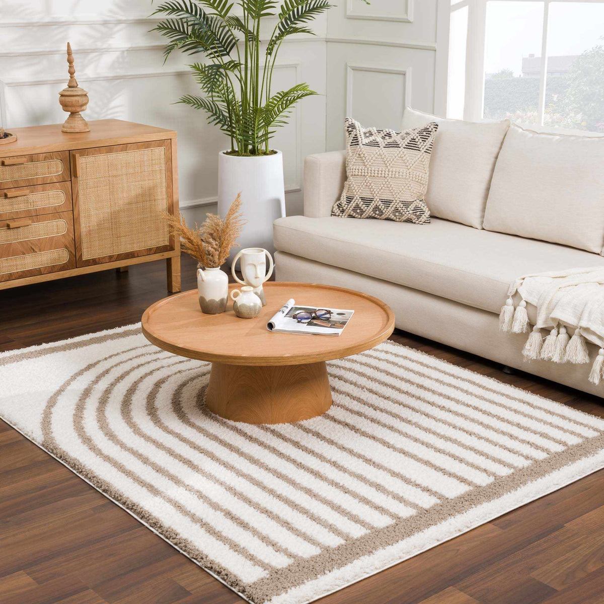 Beige Jola area rug by Boutique Rugs, displayed in a cozy living room setting with wooden flooring and decor accents.