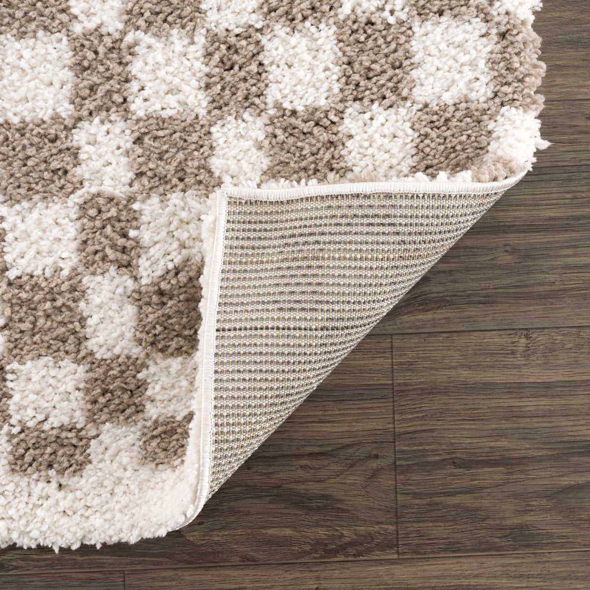 Taupe checkered shag rug by Boutique Rugs, folded to show soft, plush texture and modern geometric pattern.