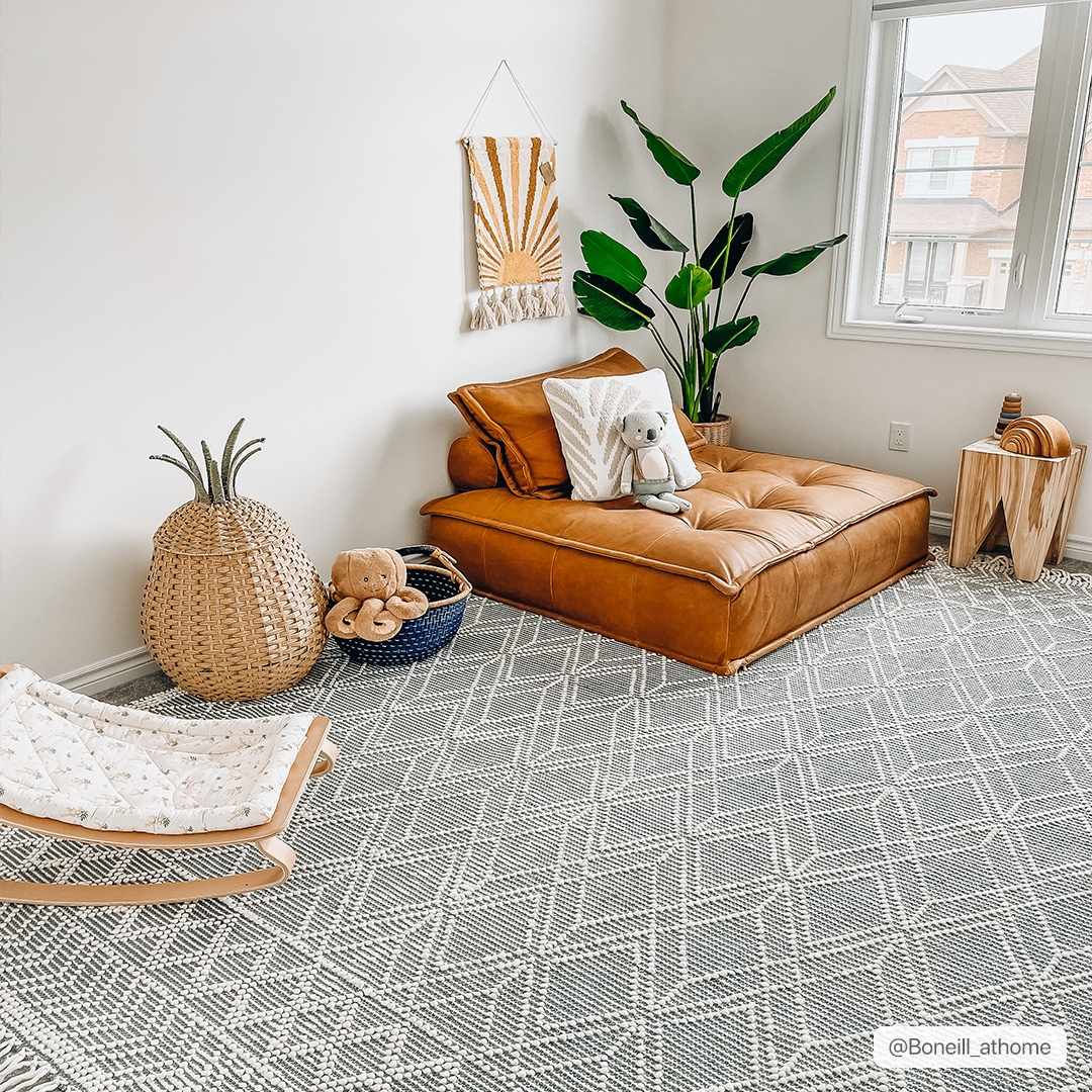 Hauteloom Ramsbury Ivory and Blue area rug featuring a detailed pattern, displayed on a hardwood floor in a modern living room.