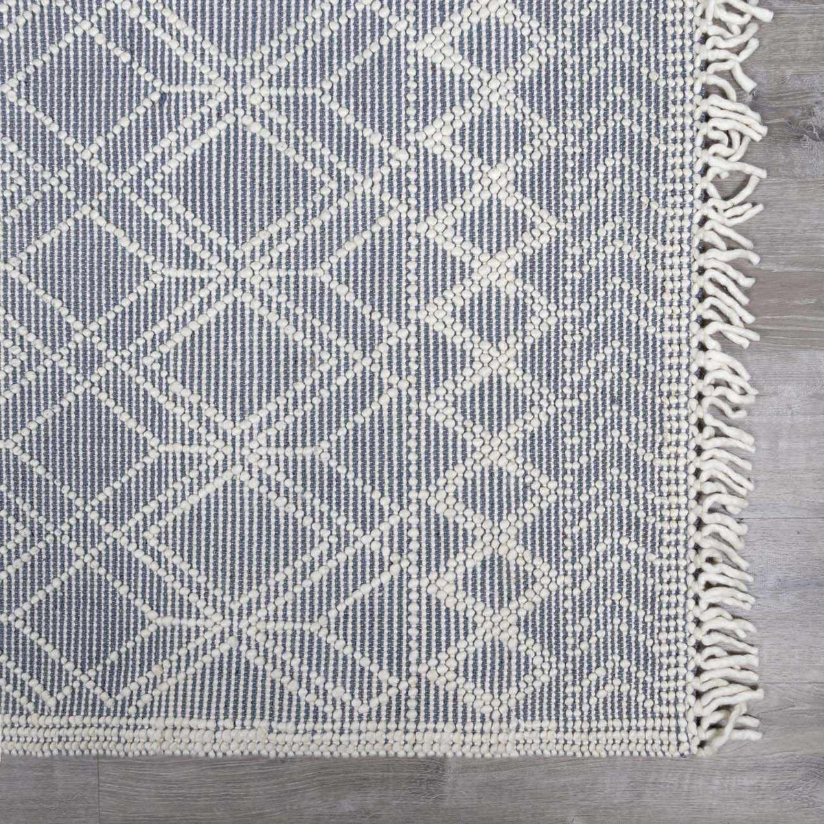 Corner view of Ramsbury Denim Blue Wool Rug by Boutique Rugs, showcasing soft wool texture and stylish blue color.