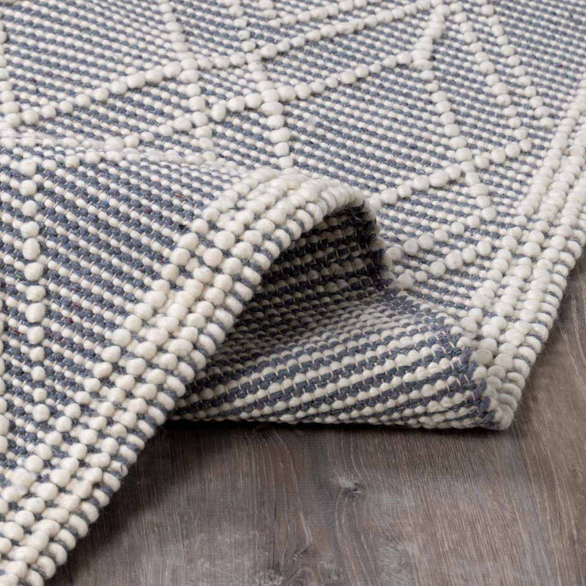 Blue Wool Rug from Ramsbury Denim collection by Boutique Rugs, folded to show soft wool texture and vibrant denim blue color.