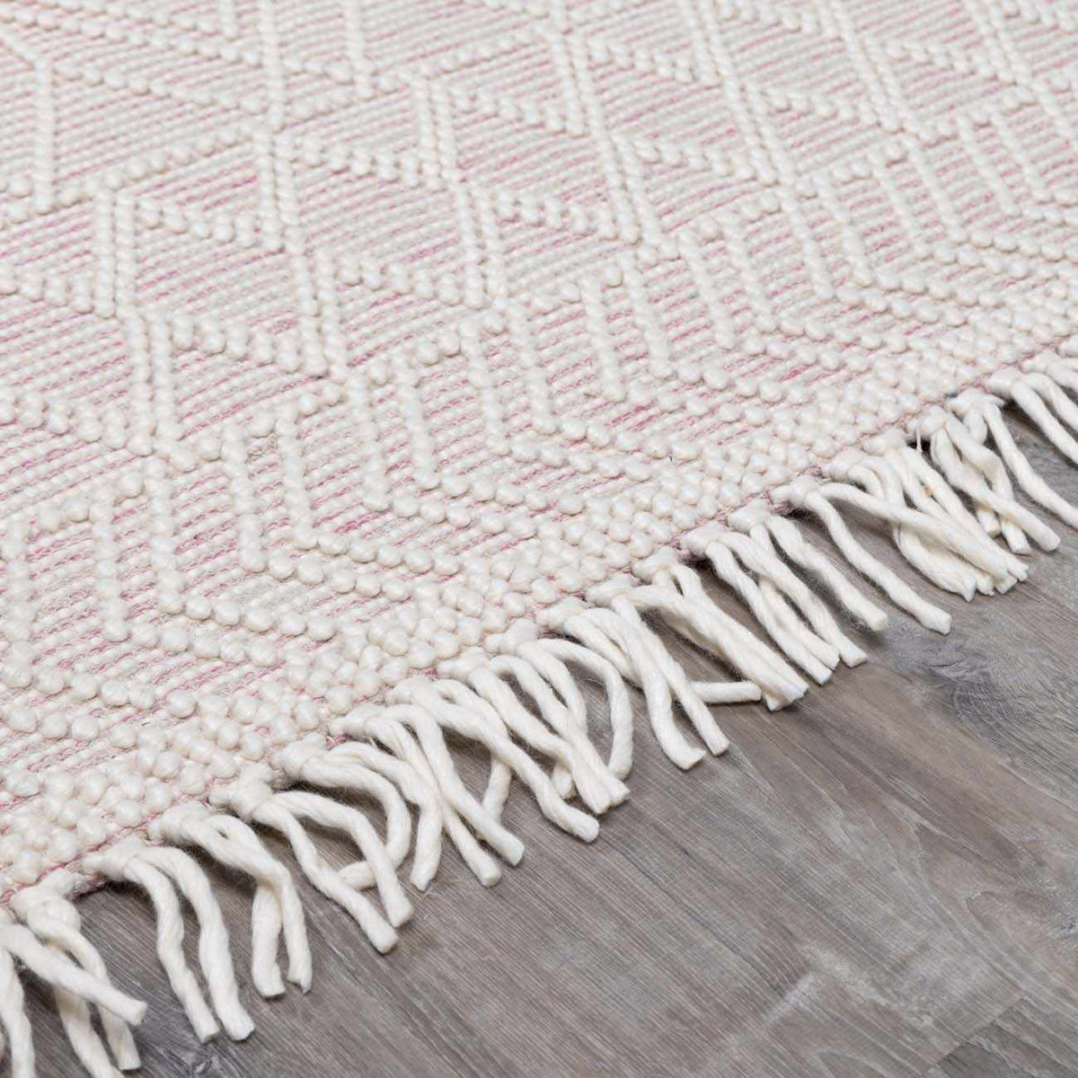 Soft pink wool rug from Boutique Rugs, featuring a plush pile and textured design, ideal for cozy living spaces.
