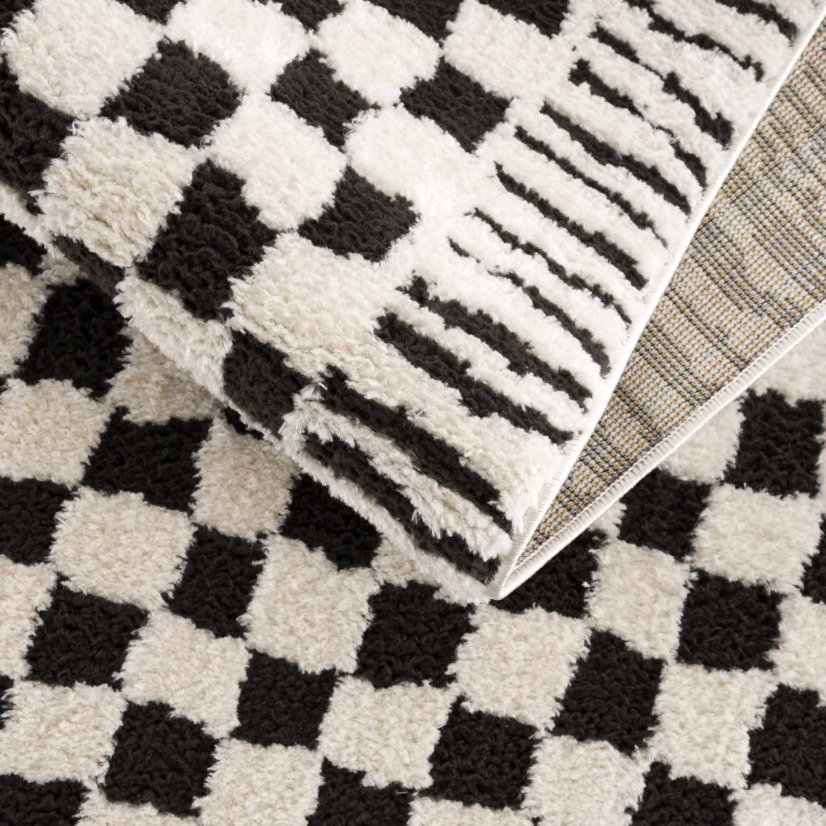 Black and white checkered area rug by Boutique Rugs, featuring a bold geometric pattern and plush texture.