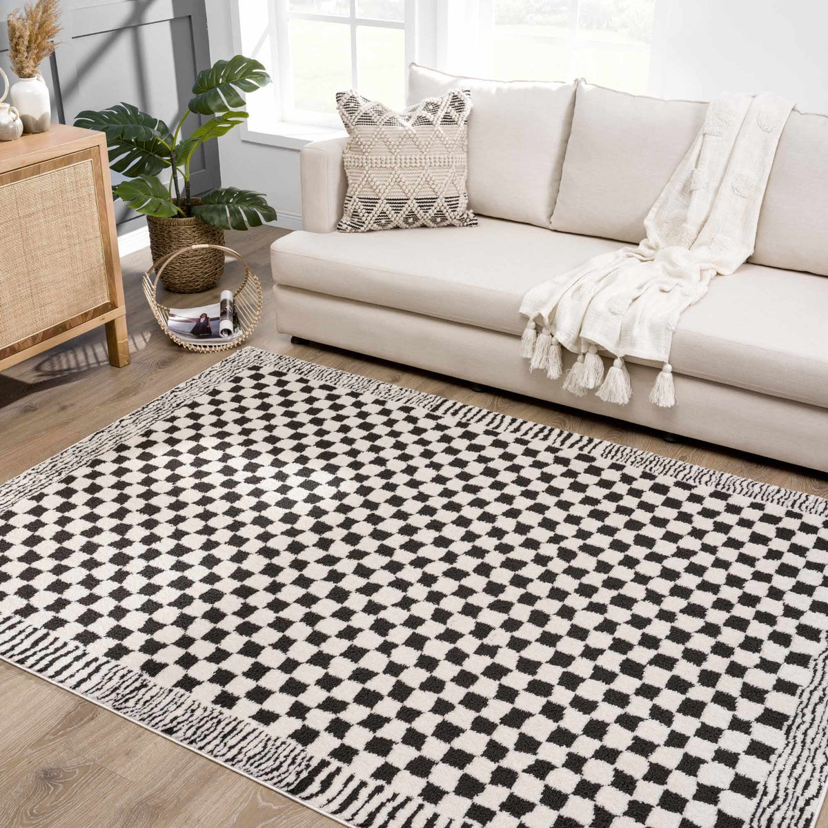 Black and white checkered area rug by Boutique Rugs, shown in a cozy living room setting with furniture and decor.