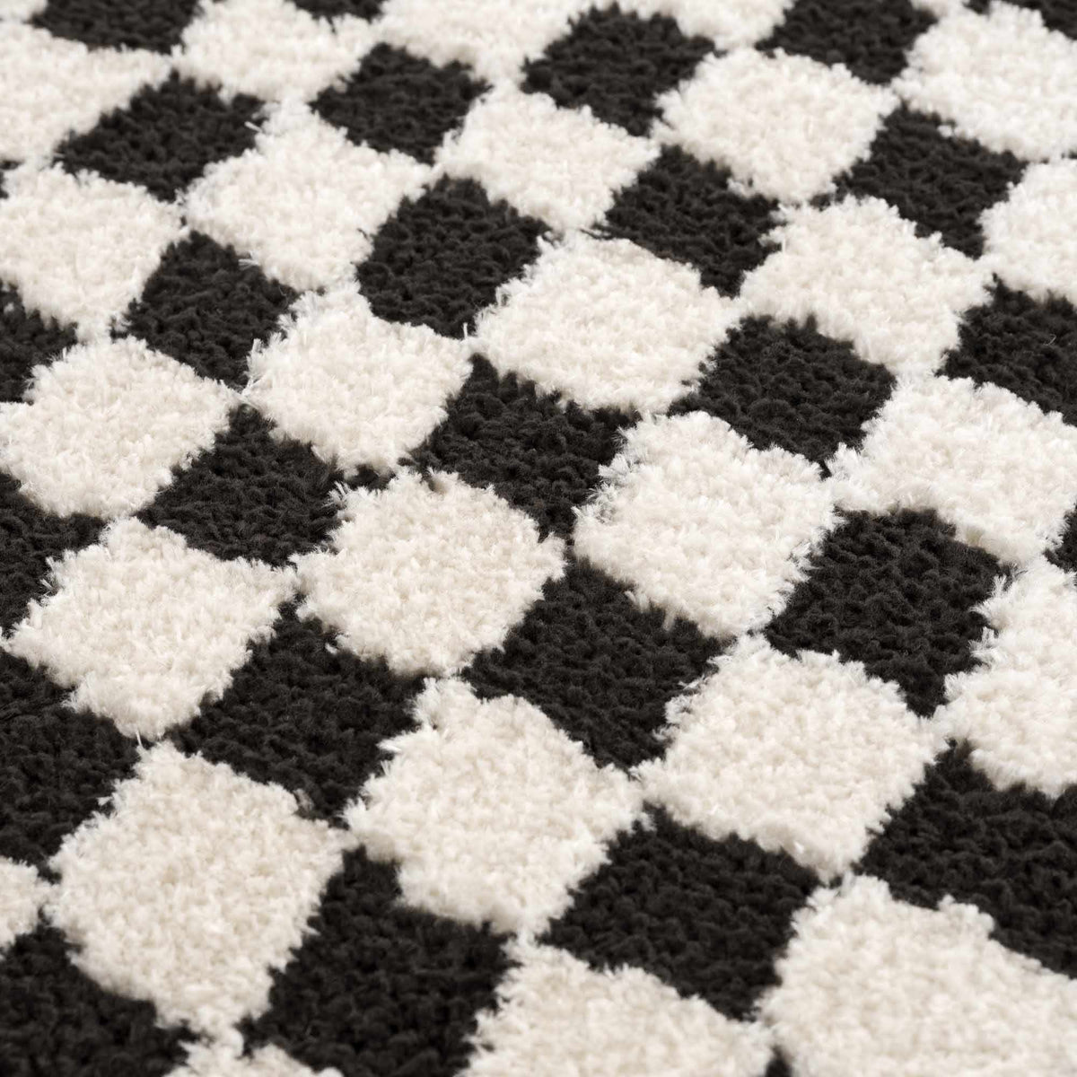Black and white checkered area rug by Boutique Rugs, showing textured fabric and bold geometric pattern in a modern interior.