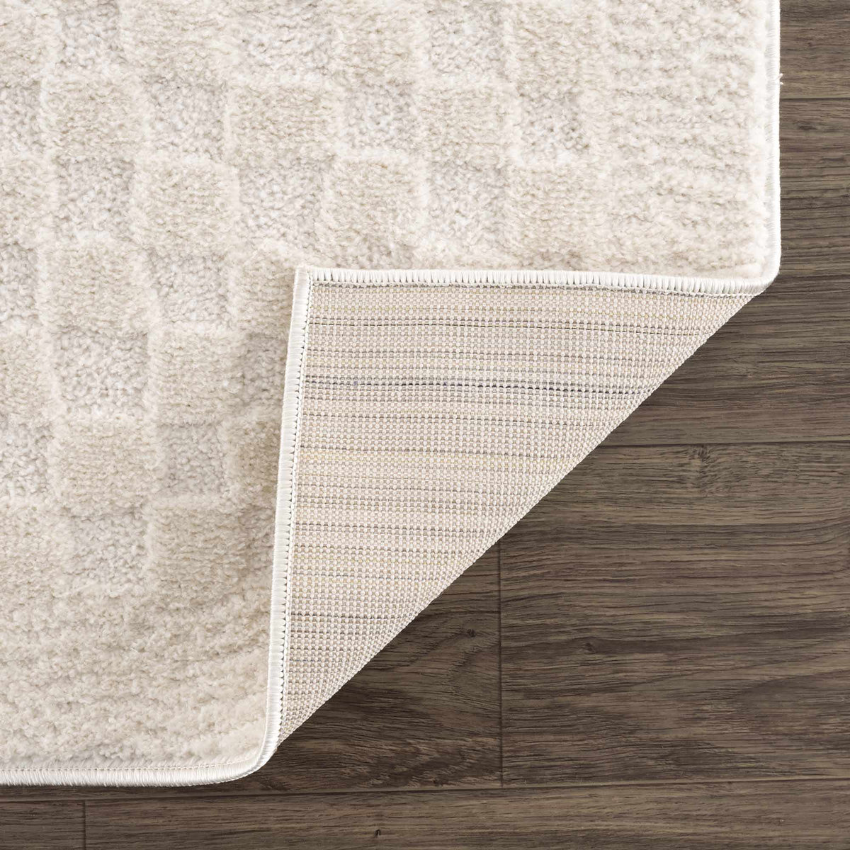 Ivory checkered area rug from Boutique Rugs, featuring a folded view showing its soft texture and classic pattern.