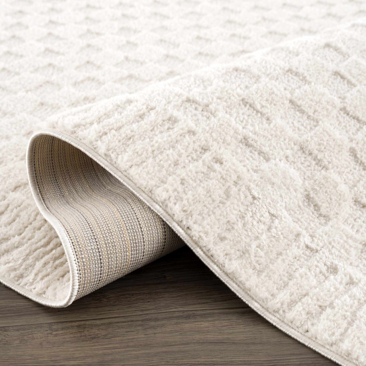 Ivory checkered area rug by Boutique Rugs, featuring a soft woven texture and classic pattern, displayed folded with a subtle geometric design.