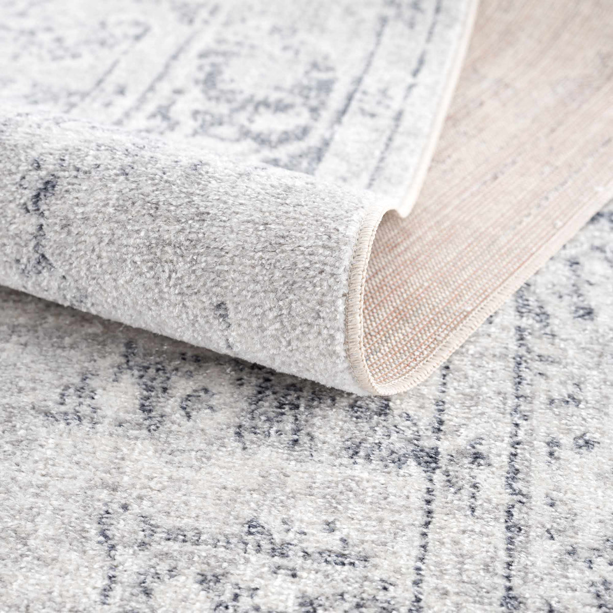 Folded Akram Antrasit flat pile washable rug by Boutique Rugs, showcasing its soft, durable gray design and textured surface.
