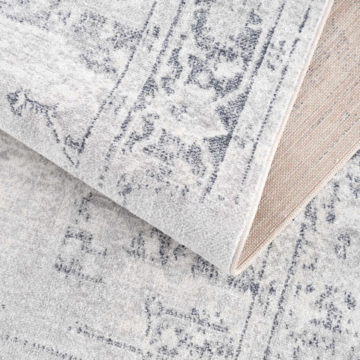 Folded Akram Antrasit flat pile washable rug from Boutique Rugs, showing its soft dark gray fabric and textured surface.