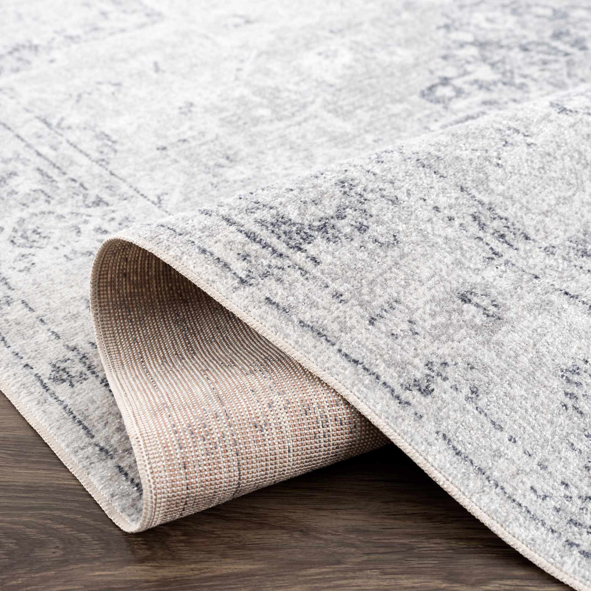 Folded Akram Antrasit flat pile washable rug by Boutique Rugs, showing textured dark gray surface and soft fabric details.