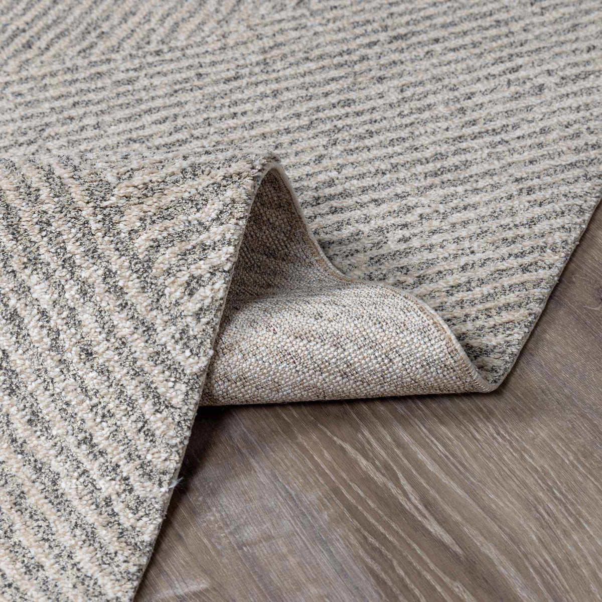 Boutique Rugs Horsley area rug folded to showcase its textured pattern and neutral color in a cozy interior setting.
