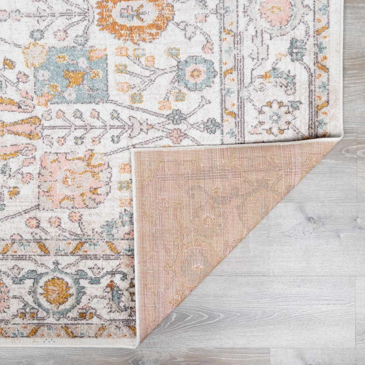 Folded Herstmonceux area rug by Boutique Rugs showcasing a soft, patterned rug with intricate details and warm tones.