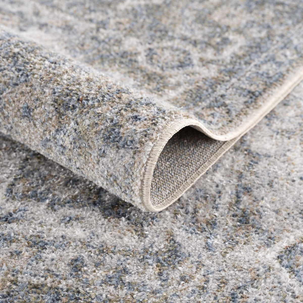 Blue Gael Boutique washable rug from Boutique Rugs, folded to show soft texture and vibrant color in a modern home setting.