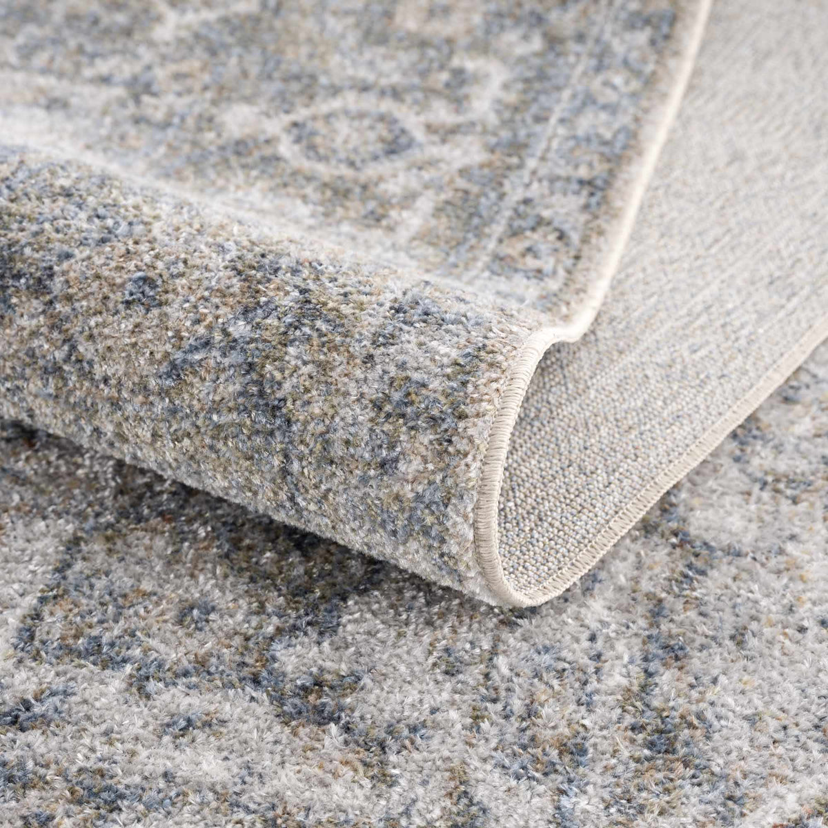 Folded Gael Blue Boutique washable rug from Boutique Rugs, showcasing soft fabric and vibrant blue color on a neutral background.