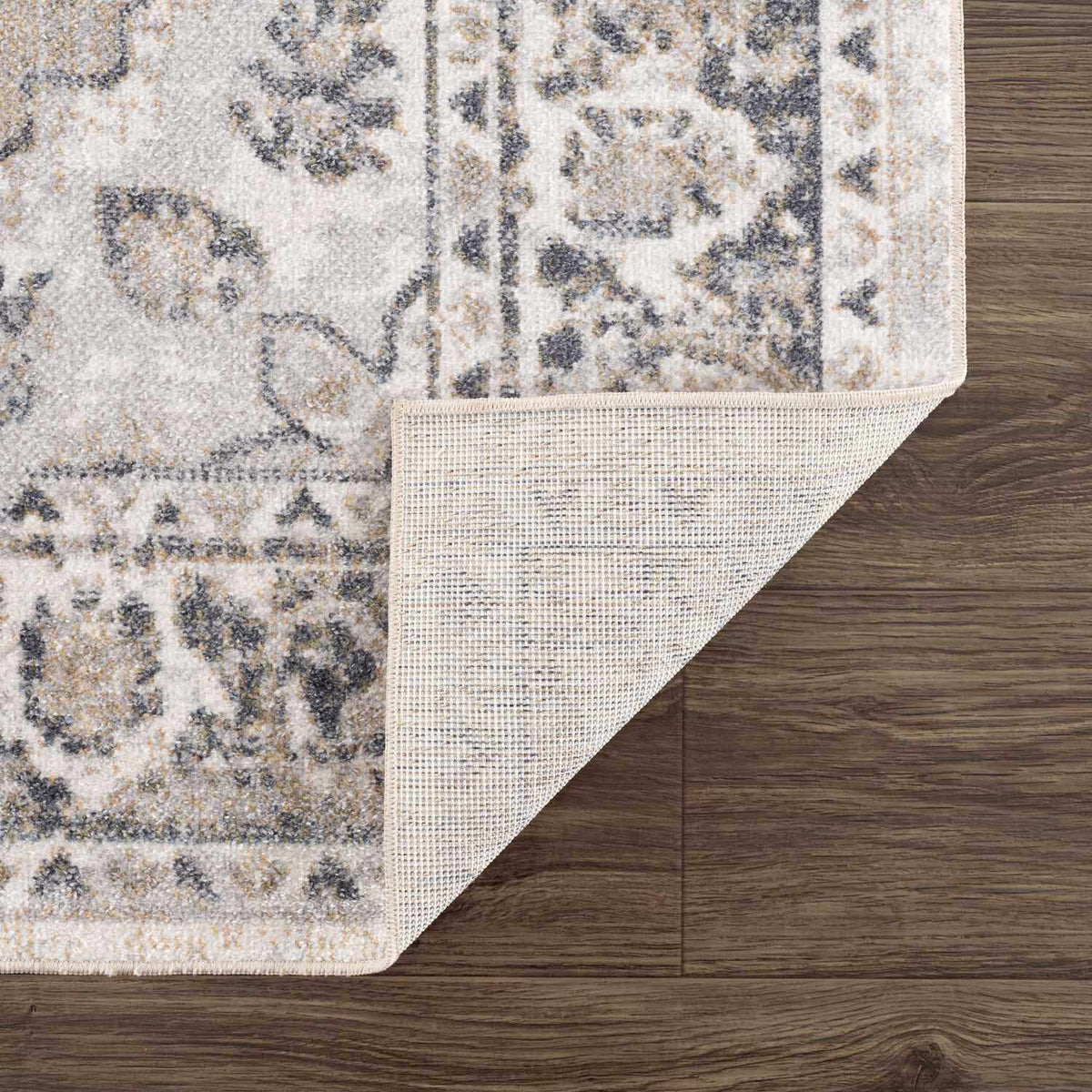 Beige washable flat pile rug by Boutique Rugs, folded to show soft texture and durable material suitable for living spaces.