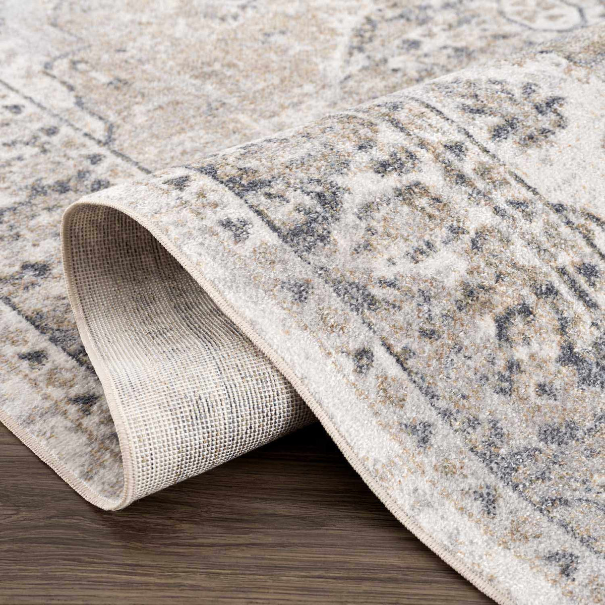 Folded beige washable rug from Boutique Rugs, flat pile design, ideal for modern living spaces, shown in a studio setting.