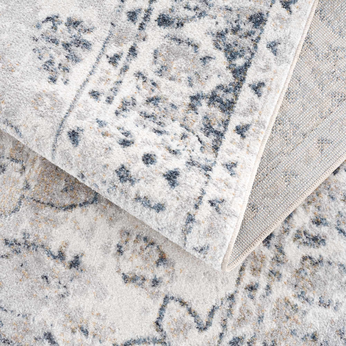 Folded Rudo Flat Pile Washable Rug by Boutique Rugs, showcasing soft, durable fabric and neutral design for modern home decor.