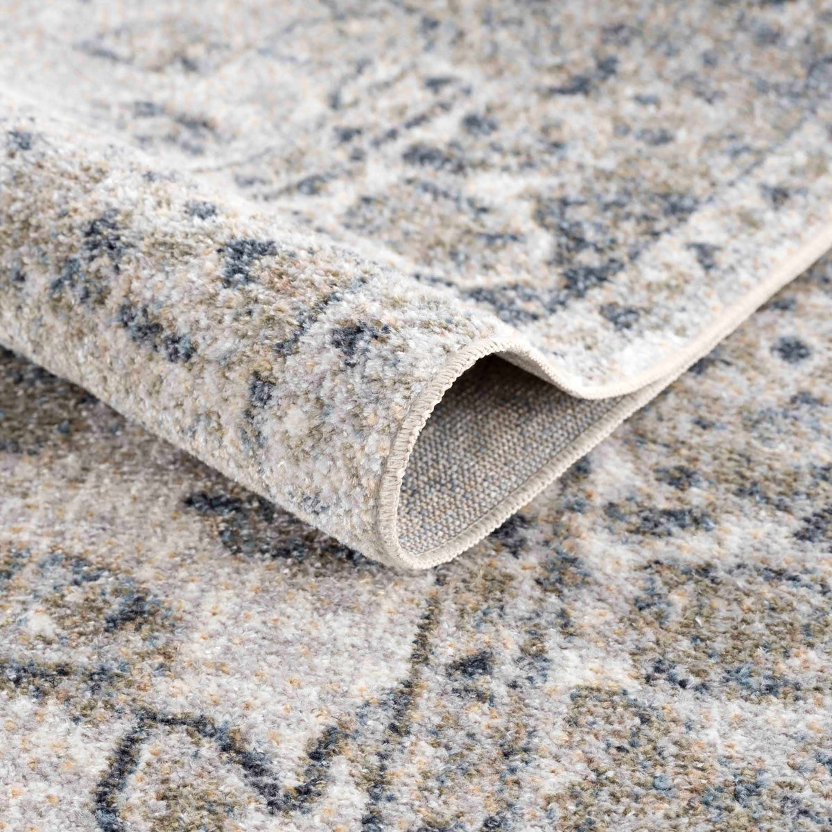 Folded Rudoblu Boutique washable rug from Boutique Rugs, showcasing its soft texture and versatile design in a cozy studio setting.