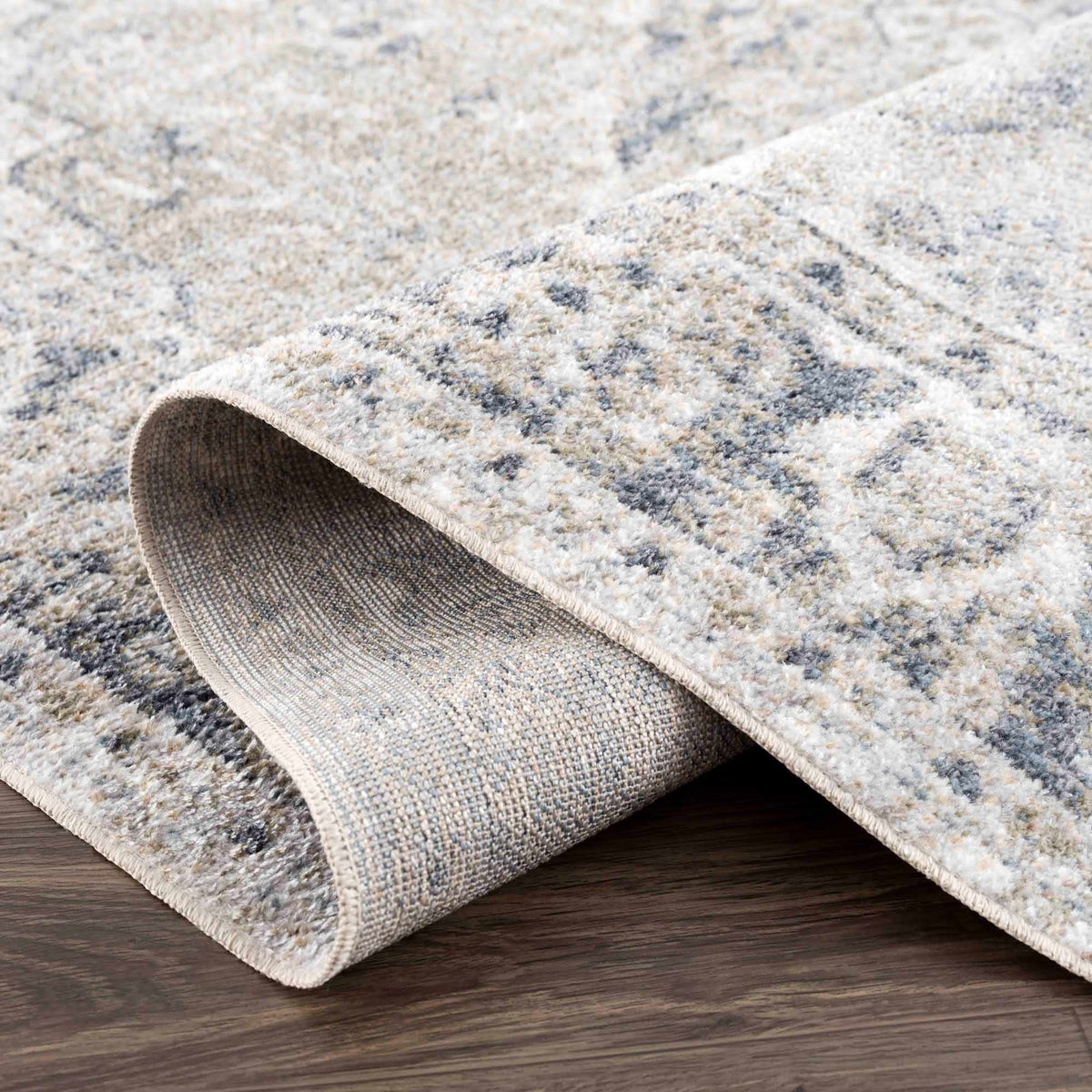 Folded Rudoblu Boutique washable rug from Boutique Rugs displaying its textured fabric and vibrant pattern in a studio setting.