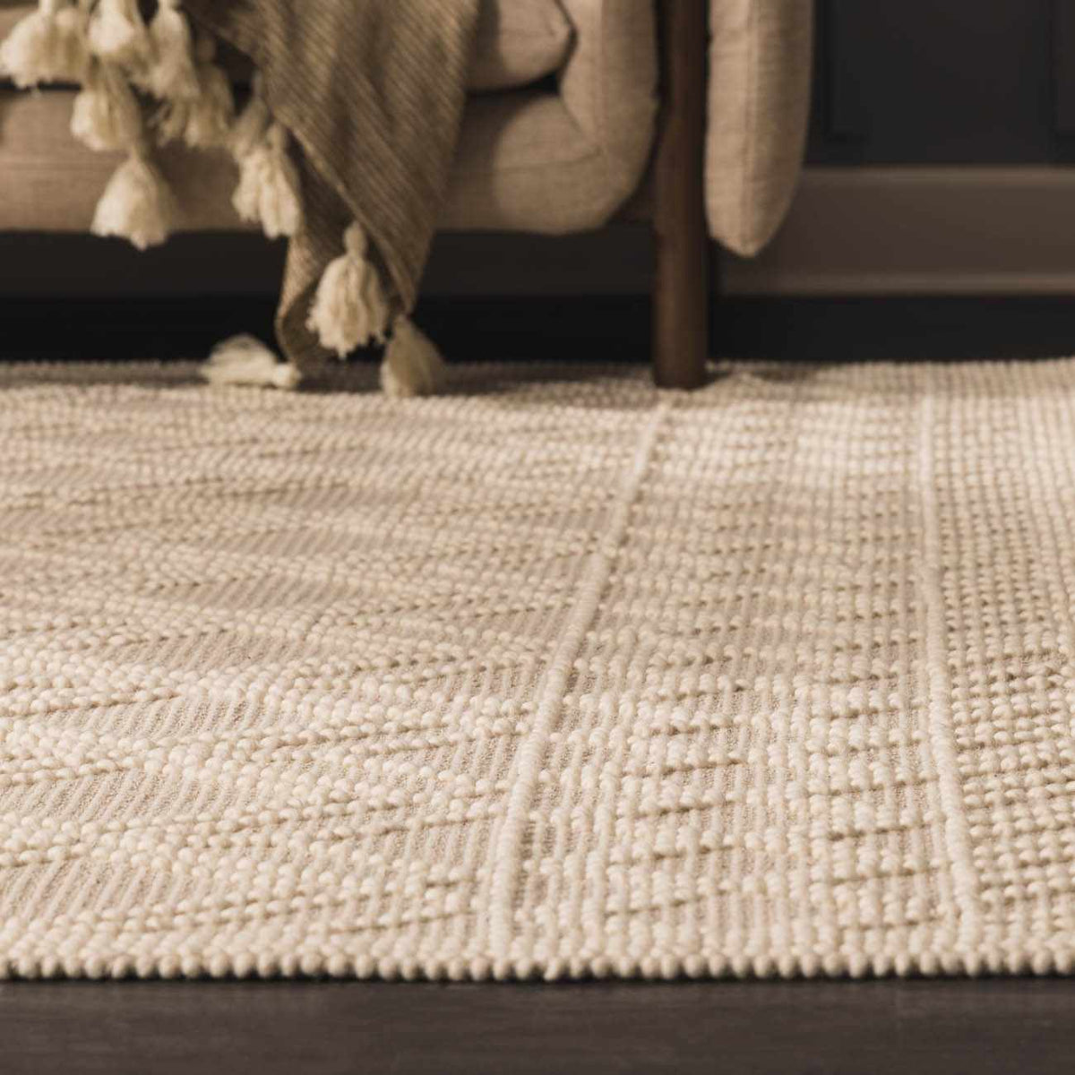 Beige trellis wool rug from Boutique Rugs, featuring a classic pattern and soft texture, placed on a wooden floor in a cozy room scene.