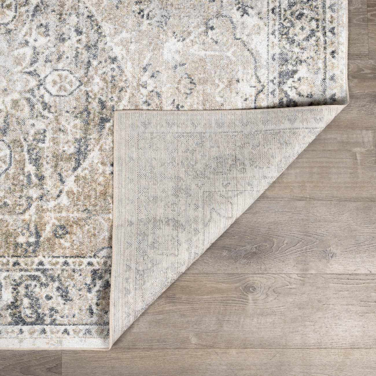 Beige flat pile washable rug by Boutique Rugs, folded to show soft texture and durable design, ideal for modern interior decor.