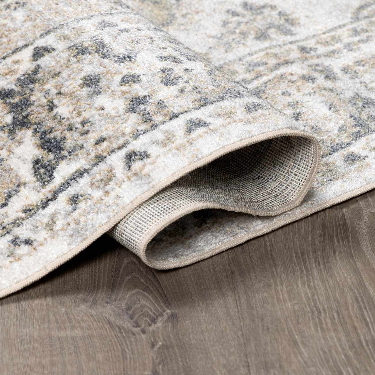 Beige flat pile washable rug from Boutique Rugs, folded to show soft texture and durable material in a neutral color.