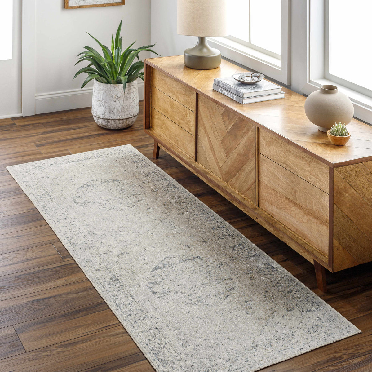 Light-colored Rudo Flat Pile Washable Rug by Boutique Rugs, shown in a cozy living room setting with furniture and decorative accents.