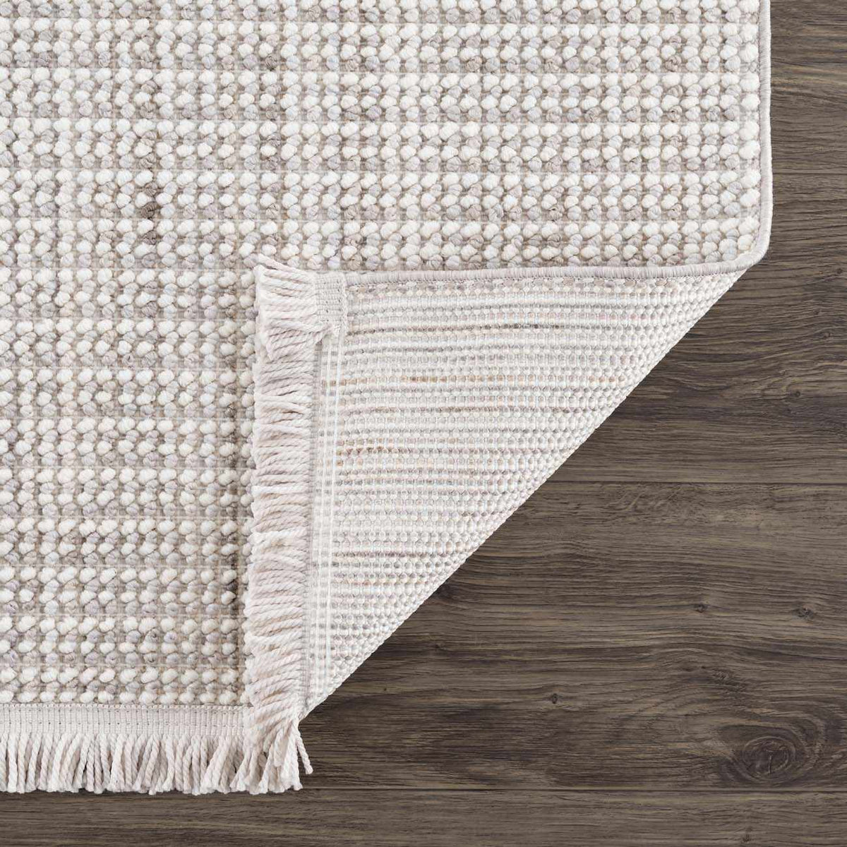 Folded Gowan Cream area rug by Boutique Rugs, showing soft cream color and plush texture in a studio setting.