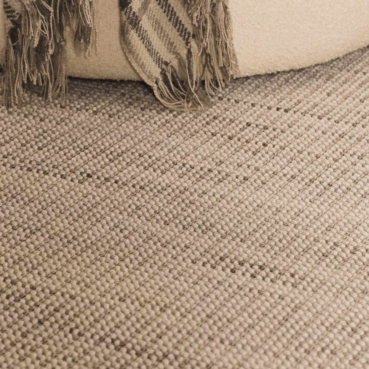 Gowan Cream Area Rug by Boutique Rugs displayed in a living room setting with neutral tones and modern decor.
