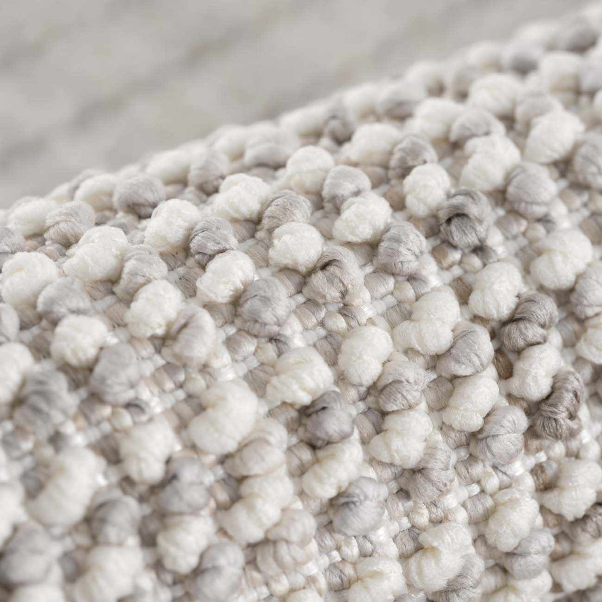 Close-up of the Gowan Cream Area Rug by Boutique Rugs, showing its textured cream fabric and detailed weave pattern.