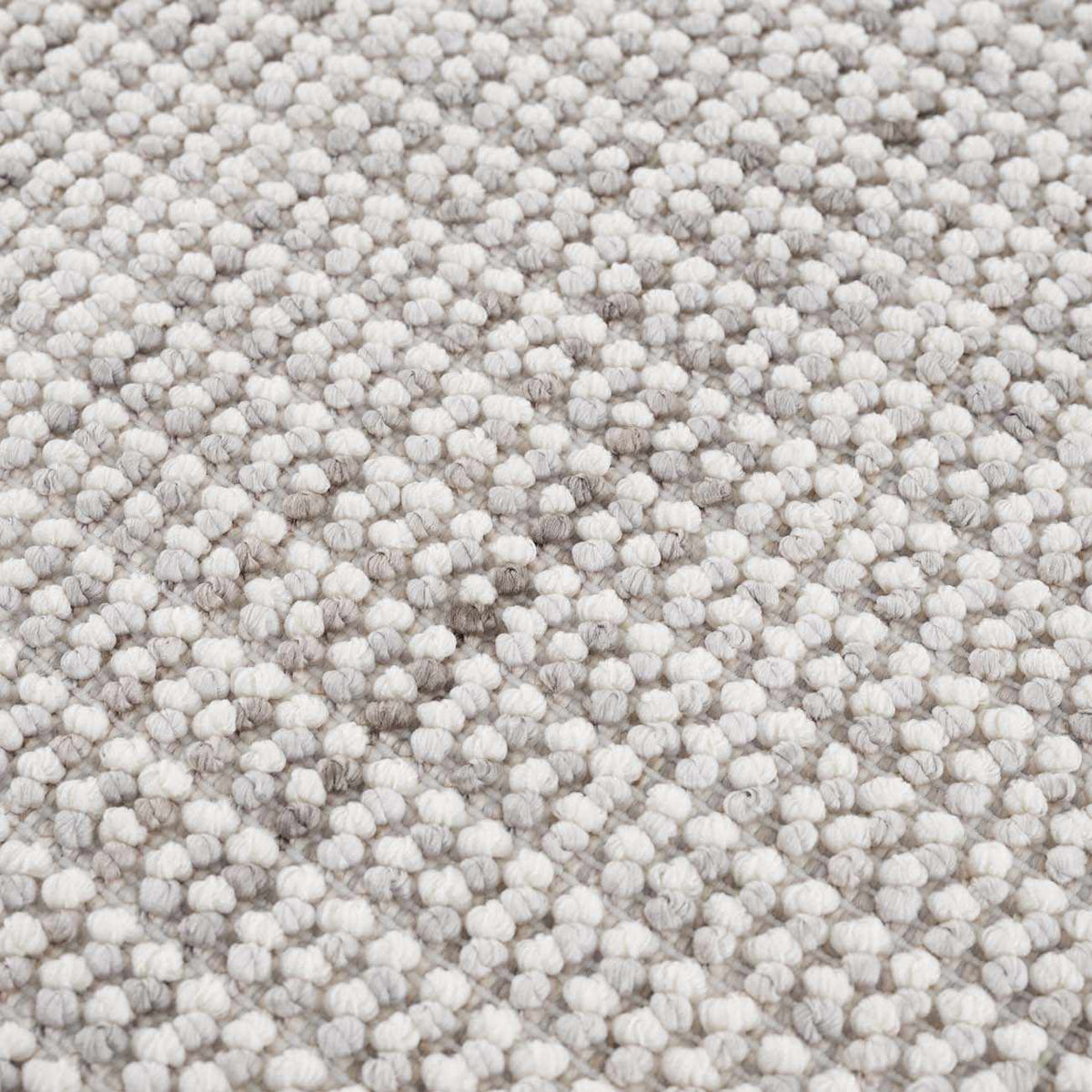 Close-up of the Gowan Cream Area Rug by Boutique Rugs, showcasing its textured, neutral-toned design in a studio setting.