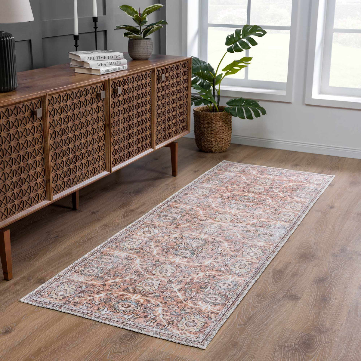 Hauteloom Urpi Rose and Brown washable area rug in a room setting with floral and geometric patterns.