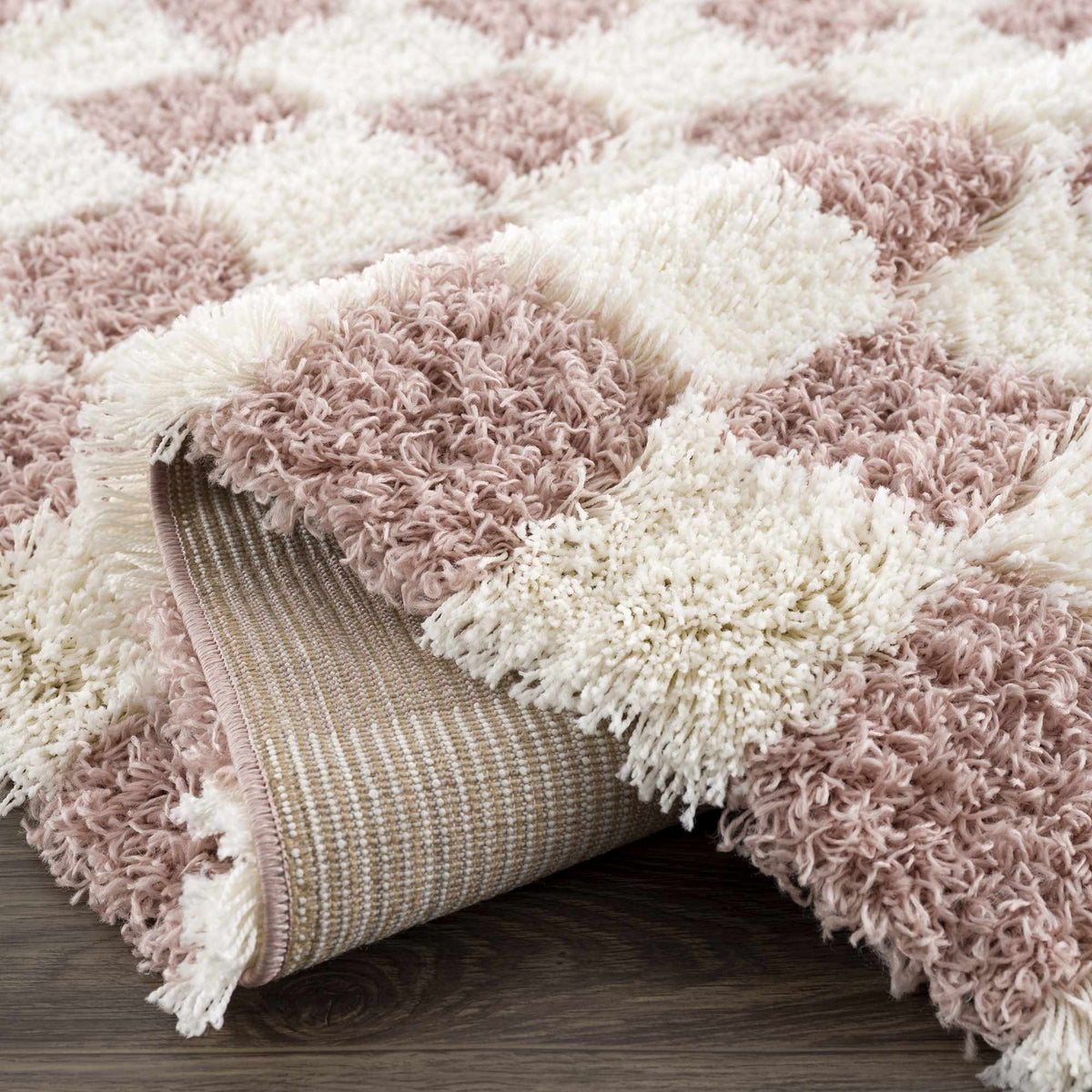 Pink checkered shag rug from Boutique Rugs, folded to show soft, plush texture and vibrant pattern in a stylish interior setting.