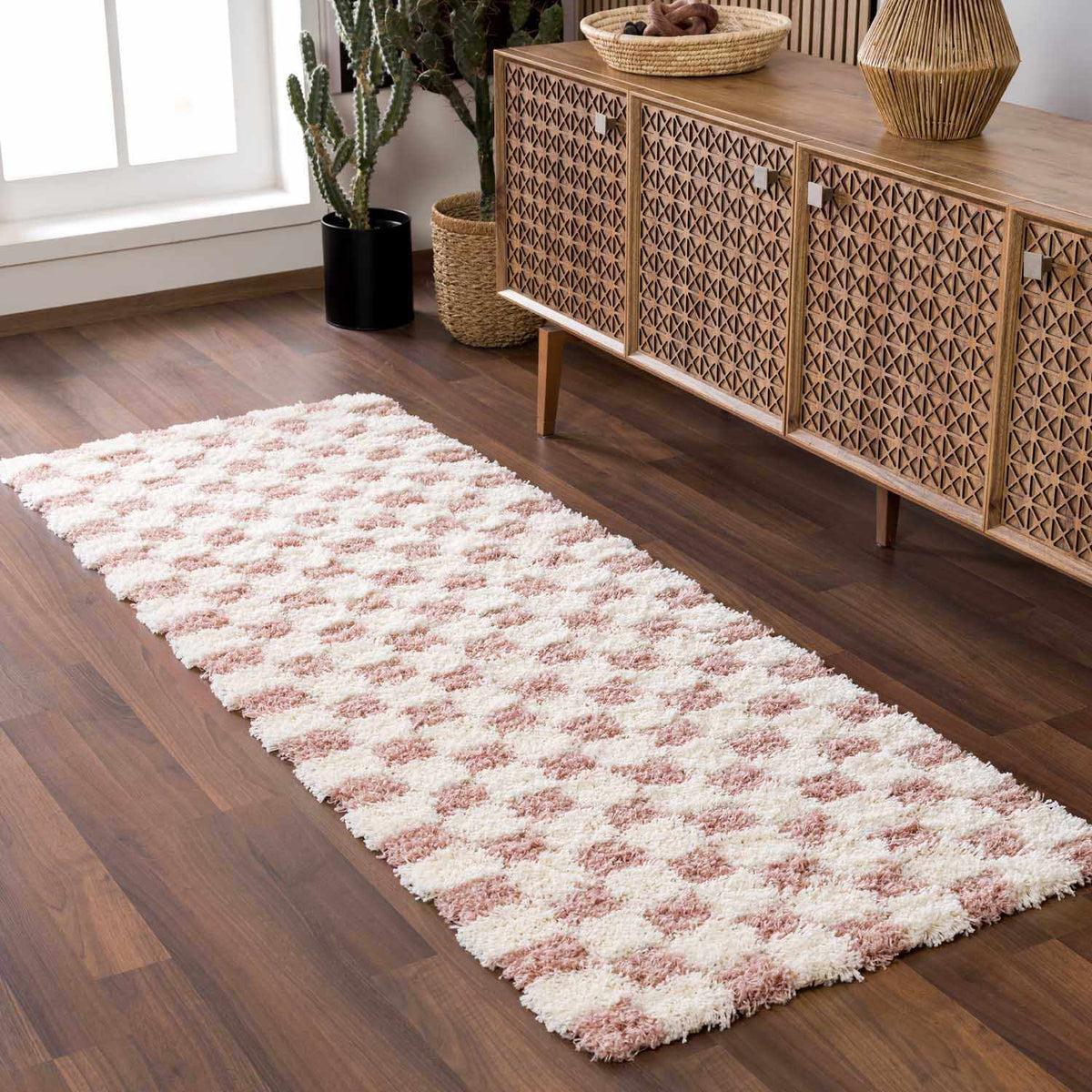 Pink checkered shag rug from Boutique Rugs, shown in a cozy room scene with soft textures and vibrant pattern.