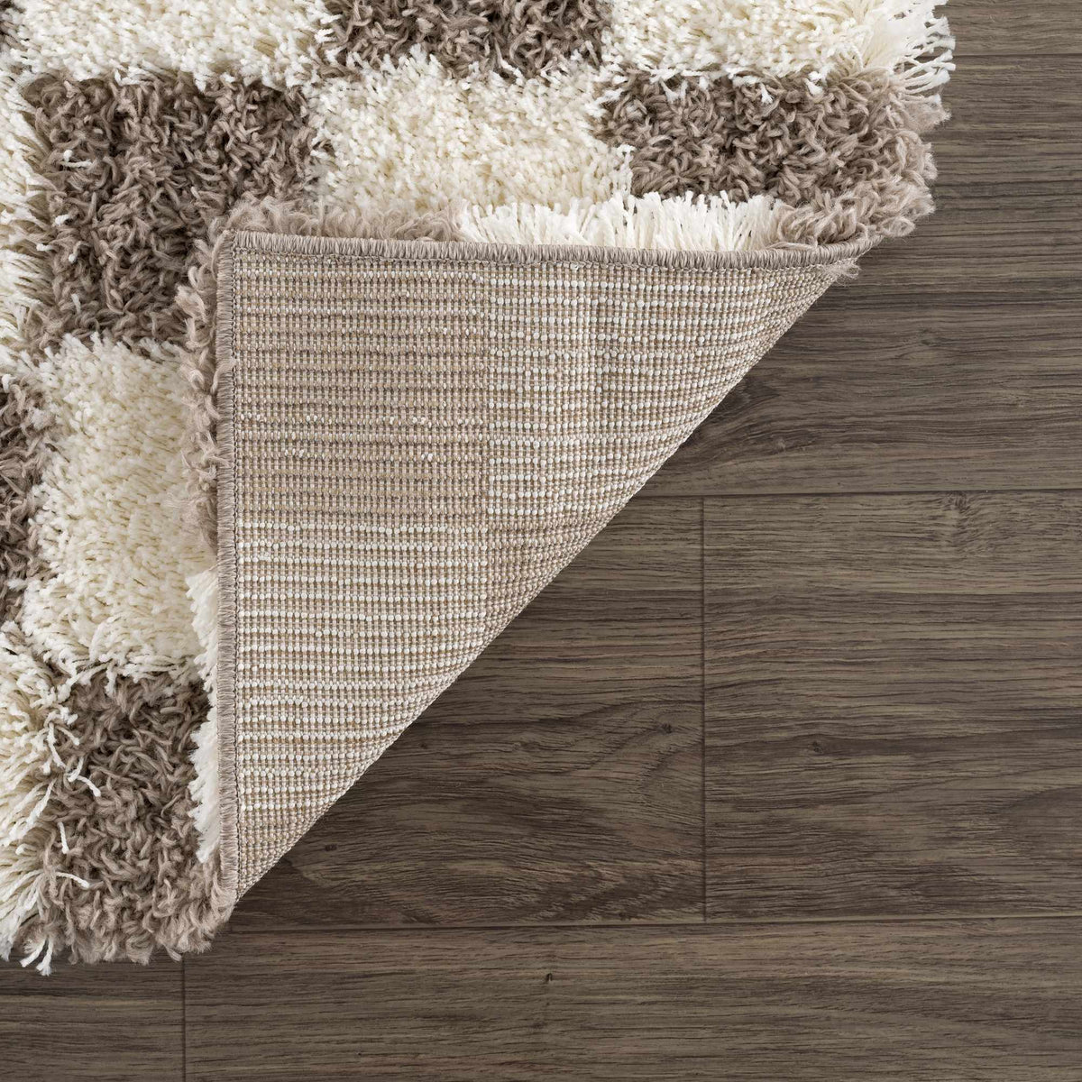 Folded Atira brown checkered area rug by Boutique Rugs, showcasing its textured checkered pattern and soft fabric.