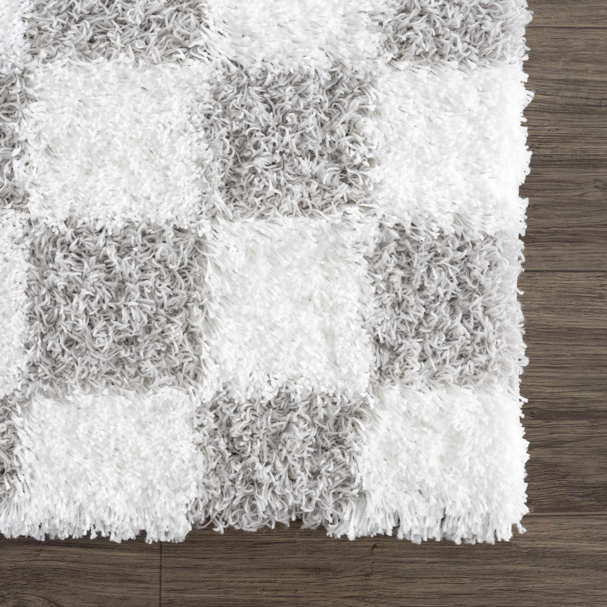 Corner view of the Atira gray checkered area rug by Boutique Rugs, featuring a soft, modern pattern on a plush surface.