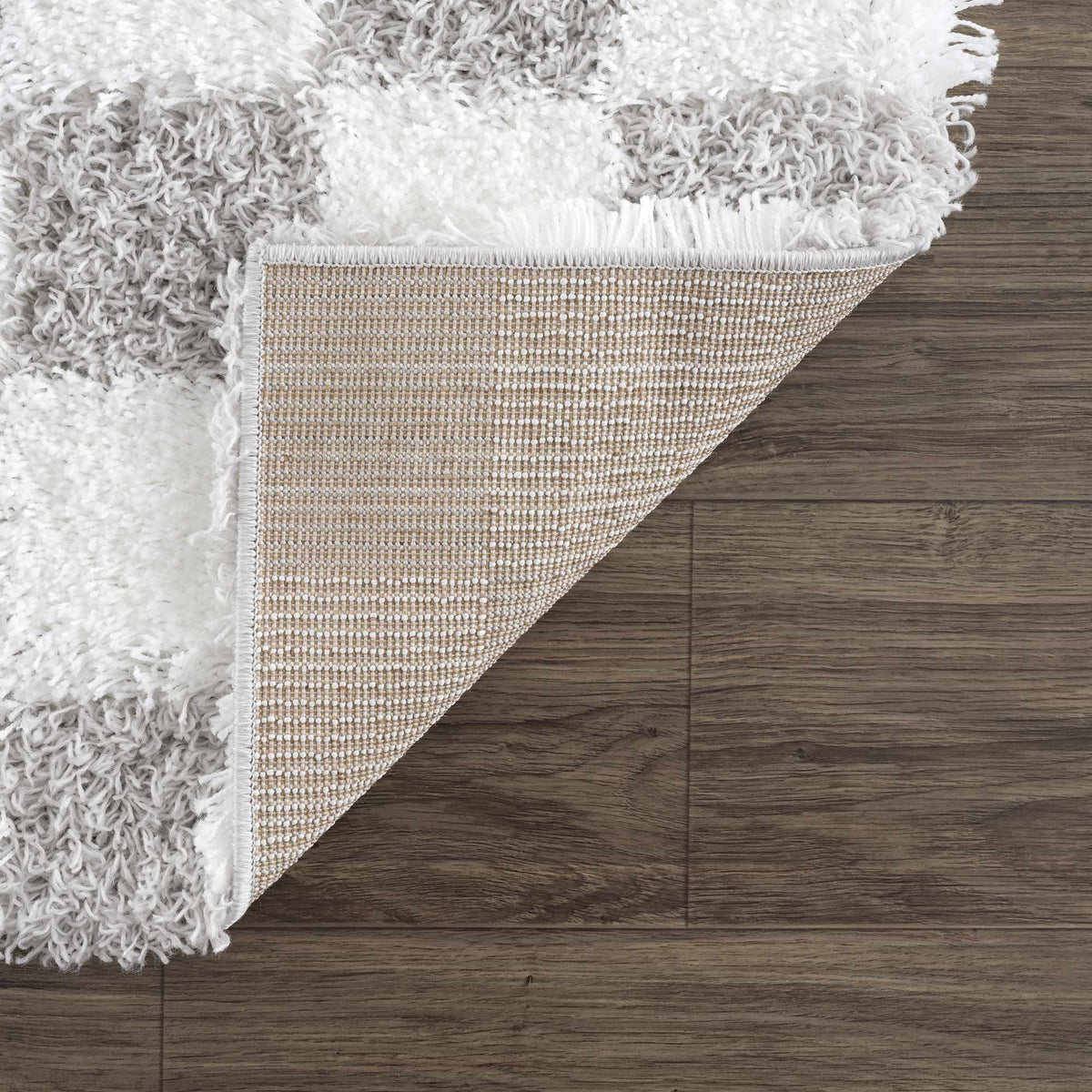 Gray checkered area rug by Boutique Rugs, shown folded with soft fabric and subtle pattern, perfect for living room or bedroom decor.