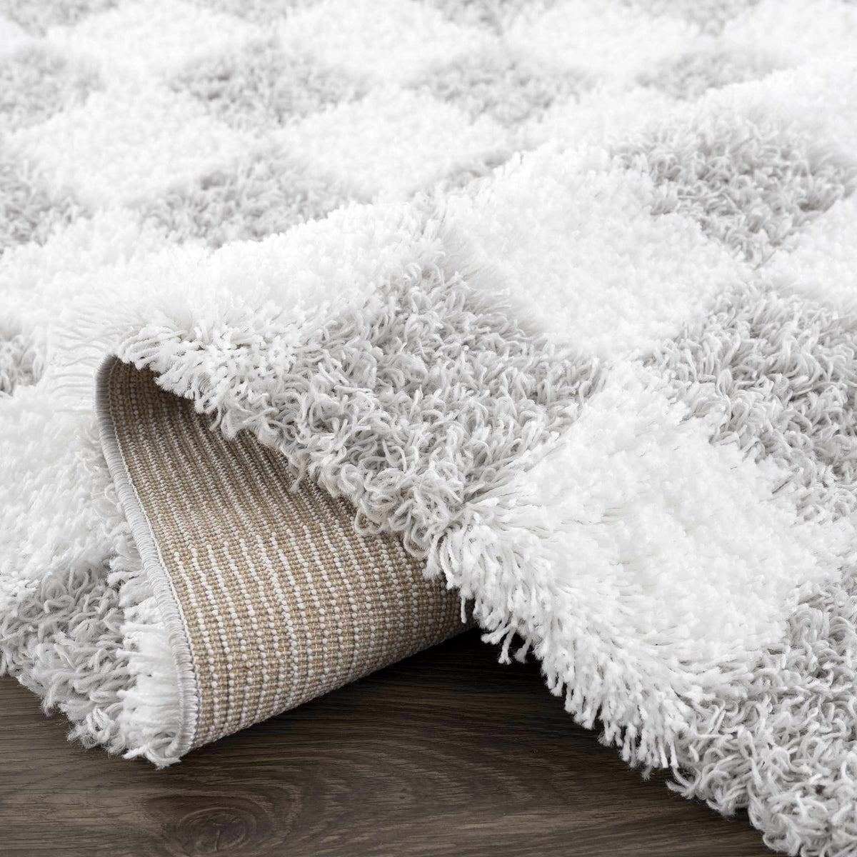 Gray checkered area rug by Boutique Rugs, featuring a stylish pattern and soft texture, shown folded on a studio background.