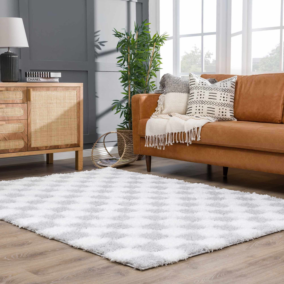 Gray checkered Boutique Rugs area rug displayed in a living room scene, showcasing its stylish checkered pattern and soft texture.