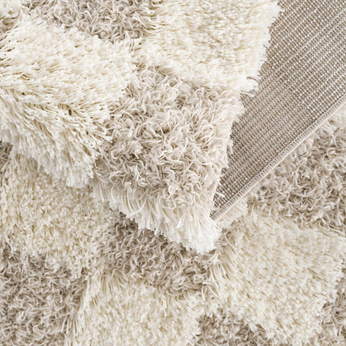 Light brown checkered area rug from Boutique Rugs, featuring a folded corner and textured pattern in a cozy living space setting.