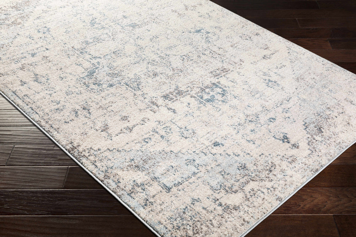 Corner view of Hauteloom Orrick area rug featuring a detailed, textured design in neutral tones, ideal for modern living spaces.